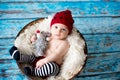 Little baby boy with knitted hat in a basket, happily smiling Royalty Free Stock Photo