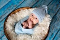 Little baby boy with knitted hat in a basket, happily smiling Royalty Free Stock Photo