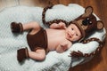 Little baby boy with knitted hat in a basket, happily smiling and looking at camera Royalty Free Stock Photo