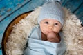 Little baby boy with knitted hat in a basket, happily smiling Royalty Free Stock Photo