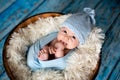 Little baby boy with knitted hat in a basket, happily smiling Royalty Free Stock Photo