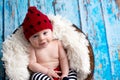 Little baby boy with knitted hat in a basket, happily smiling Royalty Free Stock Photo