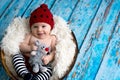 Little baby boy with knitted hat in a basket, happily smiling Royalty Free Stock Photo