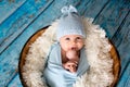Little baby boy with knitted hat in a basket, happily smiling Royalty Free Stock Photo