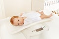 Little baby boy lay on scale for measuring body Royalty Free Stock Photo