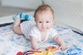 Little baby boy 3 months old lies on his stomach on the sofa in a bright room, the child smiles Royalty Free Stock Photo