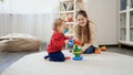 Little baby boy with mother playing with educational toys and learning building colorful tower. Baby development, child playing Royalty Free Stock Photo