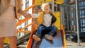 little baby boy with mother riding down the slide on playground. Happy parenting, family having time together, kids and parents Royalty Free Stock Photo