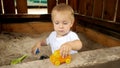 Little baby boy playing with colorful toys and cars in sandpit at park. Kids playing outdoors, children having fun, summer Royalty Free Stock Photo