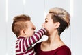 Little baby boy playing with mom and closing her mouth