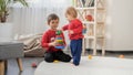 Little baby boy playing in toys with his older brother on carpet in living room. Concept of child education, baby development, Royalty Free Stock Photo