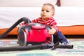 Little baby boy playing with vacuum cleaner with accessories Royalty Free Stock Photo