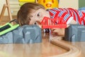 Little baby boy playing with wooden locomotive and tracks. Child development concept