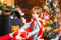 Little baby boy recieving New Year present at decorated christmas interior background. Beautiful Christmas tree and