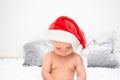Little baby boy with red santa hat looking down. One year old kid in christmas costume. Christmas time concept Royalty Free Stock Photo