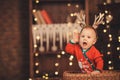 Little baby boy in reindeer antlers sitting in a wicker basket Royalty Free Stock Photo