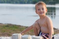 Little baby boy is resting on the sandy shore, build a castle Royalty Free Stock Photo