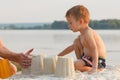 Little baby boy is resting on the sandy shore, build a castle Royalty Free Stock Photo