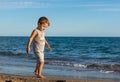 Little baby boy running along the coast of the sea. Positive human emotions, feelings,