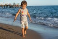 Little baby boy running along the coast of the sea. Positive human emotions, feelings,