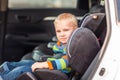 Little baby boy sitting on a car seat buckled up in the car Royalty Free Stock Photo