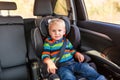 Little baby boy sitting on a car seat buckled up in the car Royalty Free Stock Photo