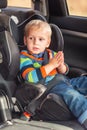 Little baby boy sitting on a car seat buckled up in the car Royalty Free Stock Photo