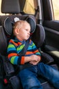 Little baby boy sitting on a car seat buckled up in the car Royalty Free Stock Photo