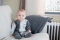 Little baby boy, sitting on a couch in a sunny living room Royalty Free Stock Photo