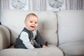 Little baby boy, sitting on a couch in a sunny living room Royalty Free Stock Photo