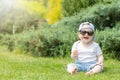 Little baby boy is sitting on the grass in sunglasses Royalty Free Stock Photo