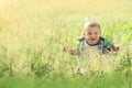 Little baby boy sitting summer outdoors grass in sun Royalty Free Stock Photo