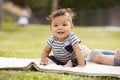 Little baby boy sitting up on a blanket in the park looking to camera, close up Royalty Free Stock Photo