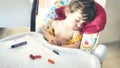 A little baby boy toddler asleep in his high-chair after playing with colored crayons Royalty Free Stock Photo