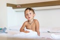 Little baby boy waked up and sitting on the white bed love Royalty Free Stock Photo