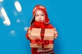 Little baby boy wear santa suit smile and show gift box with red bow on blue background. selected focus. christmas time Royalty Free Stock Photo