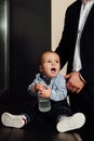 Little baby drinking water from bottle. Stylishly fashionably dressed, Royalty Free Stock Photo
