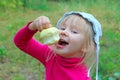 Little baby eating apple holding it in hand Royalty Free Stock Photo