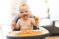 Little baby girl eating her spaghetti dinner and making a mess