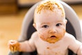 Little baby girl eating her spaghetti dinner and making a mess