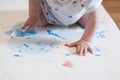 Little baby is engaged in finger painting. Early development. Todler playing with paints on drawing paper. Small child`s hands. Royalty Free Stock Photo