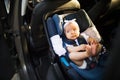 Little baby fastened with security belt in safety car seat. Royalty Free Stock Photo