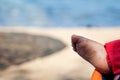 Little baby foot covered with sand on the stroller at the beach Royalty Free Stock Photo