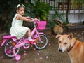 Little baby girl afraid of a dog sitting close to her, causing her to feel uncertain to continue riding