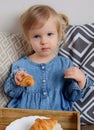 Little baby girl age of 1,11 years eating croissants