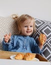 Little baby girl age of 1,11 years eating croissants