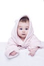 Little baby girl with blue eyes in pink bathrobe lying on her be Royalty Free Stock Photo