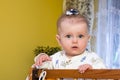 Little baby girl with bow on her head plays in the crib Royalty Free Stock Photo