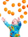 Little baby girl caughts flying oranges Royalty Free Stock Photo