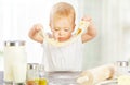 Little baby girl is cooking, kneads dough baking